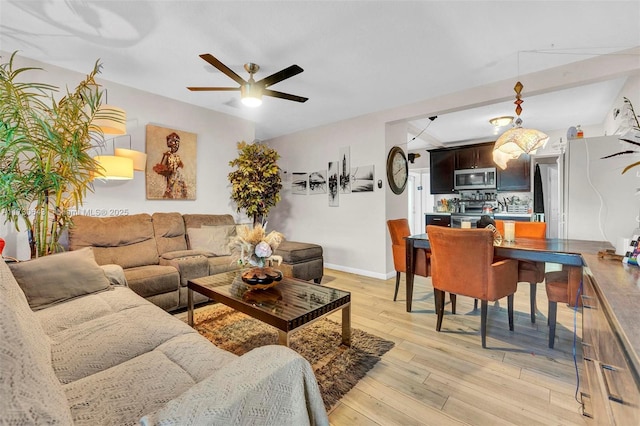 living room with ceiling fan and light hardwood / wood-style floors