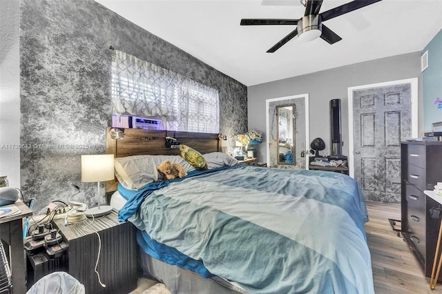 bedroom featuring cooling unit, ceiling fan, and wood-type flooring