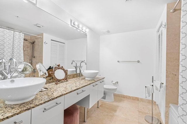 full bath with a closet, visible vents, a sink, and double vanity