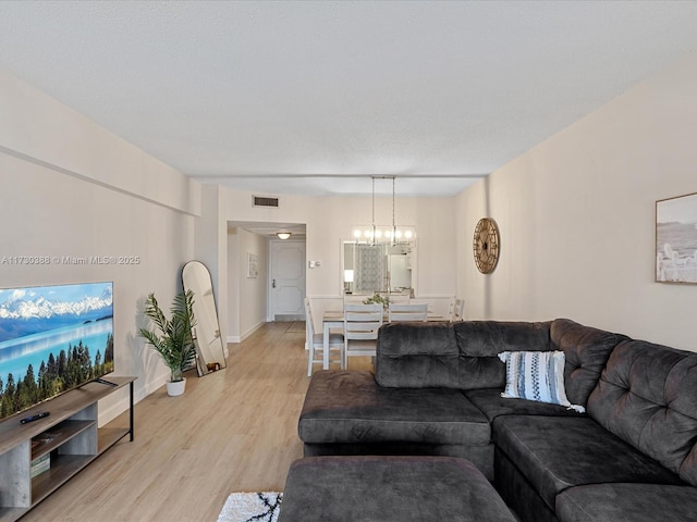 living room featuring a chandelier and light hardwood / wood-style floors