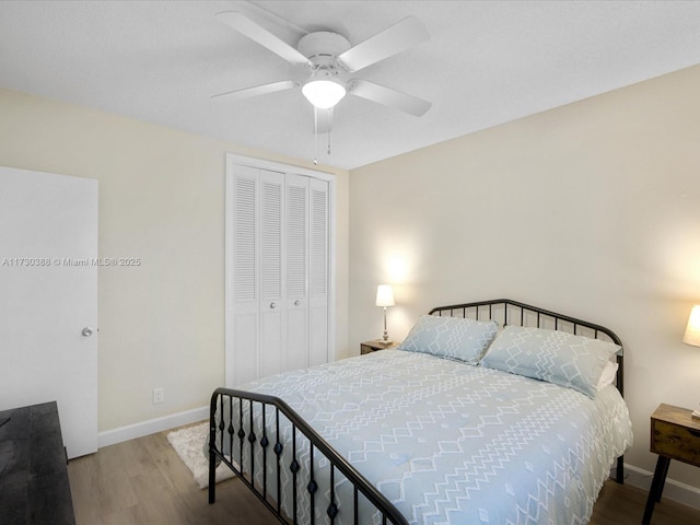 bedroom with hardwood / wood-style floors, a closet, and ceiling fan