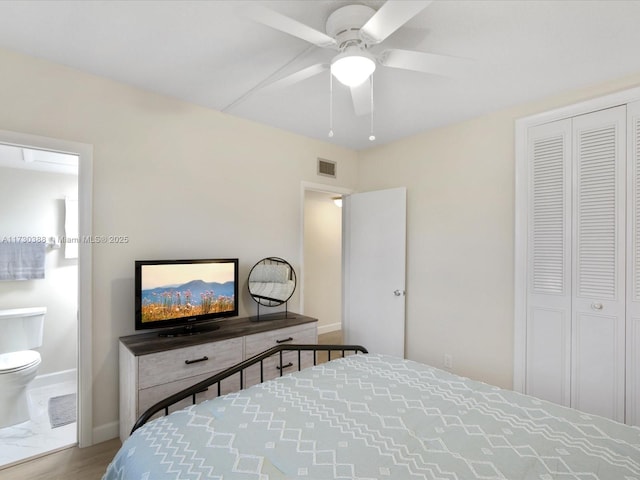 bedroom featuring ceiling fan, ensuite bathroom, and hardwood / wood-style flooring