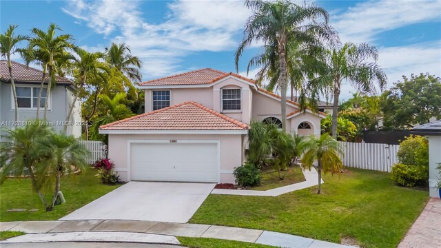 mediterranean / spanish home with a garage and a front yard