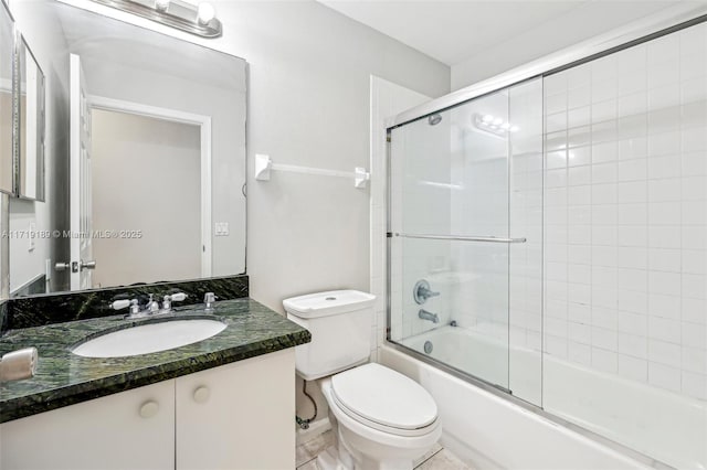 full bathroom featuring combined bath / shower with glass door, toilet, and vanity