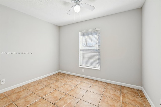 tiled empty room featuring ceiling fan