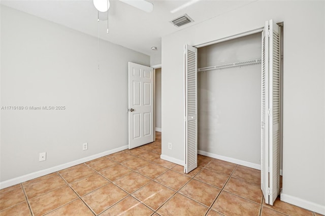 unfurnished bedroom with a closet, light tile patterned floors, and ceiling fan