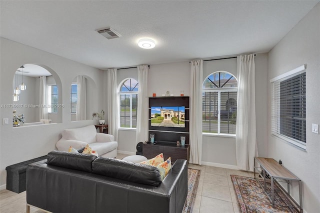 living room featuring a textured ceiling and light tile patterned floors