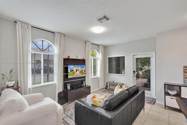 living room featuring a textured ceiling and light tile patterned floors