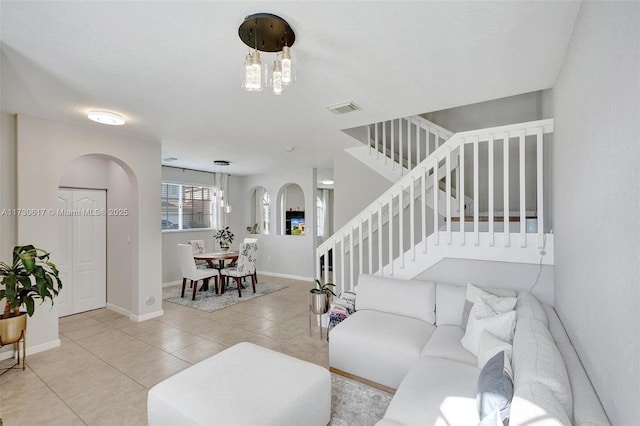 living room with a notable chandelier and light tile patterned flooring