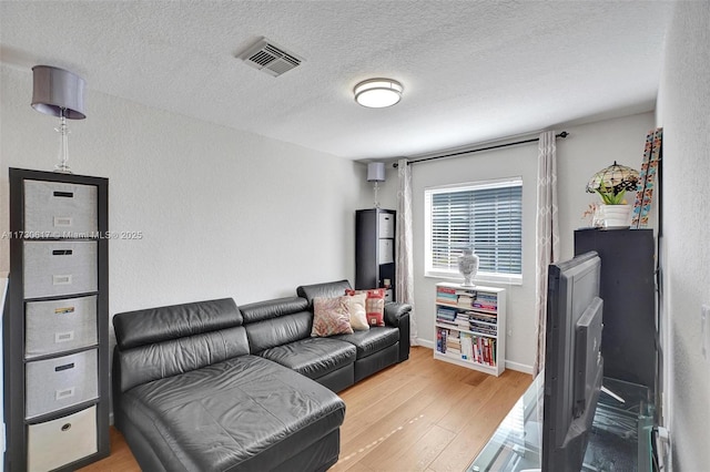 living room featuring hardwood / wood-style flooring and a textured ceiling