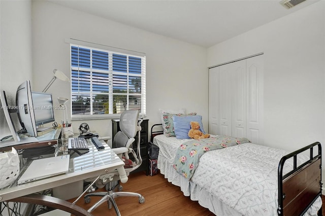 bedroom with a closet and dark hardwood / wood-style flooring