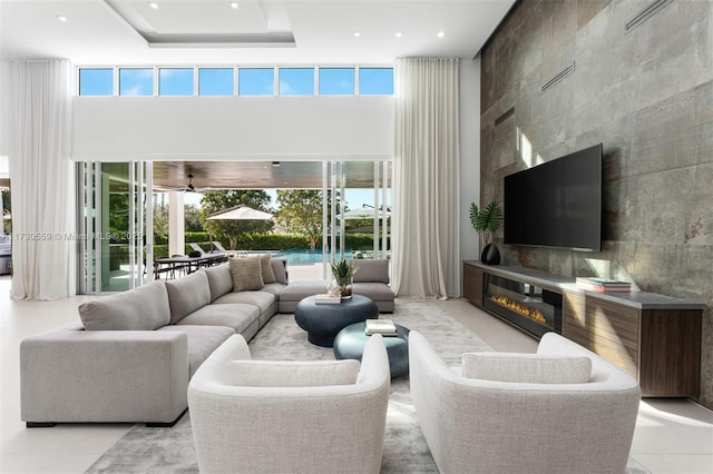 living room featuring a large fireplace, a high ceiling, and light tile patterned flooring