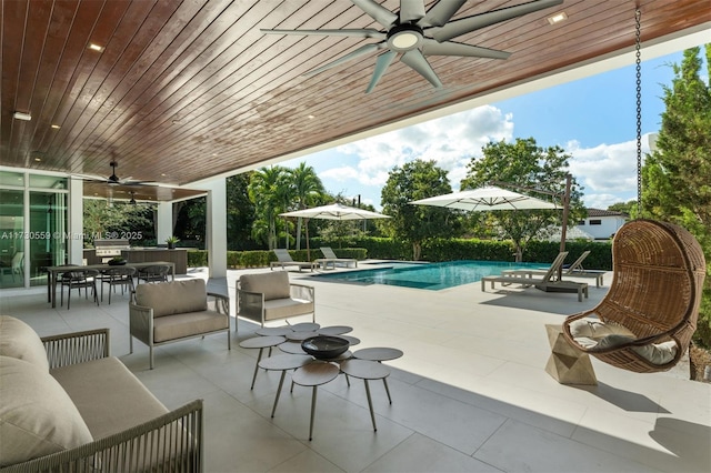 view of pool with an outdoor living space, a patio, and ceiling fan