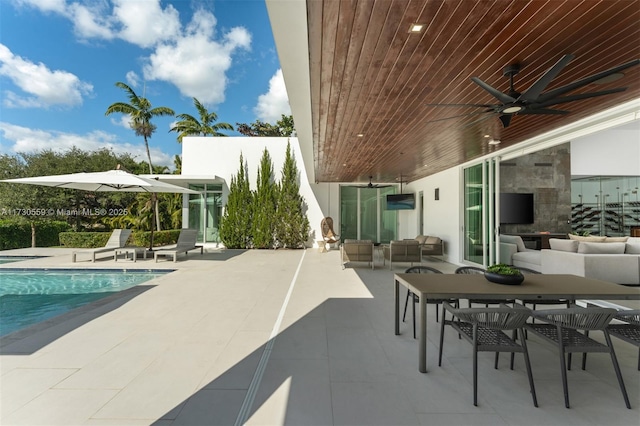 view of swimming pool featuring ceiling fan, outdoor lounge area, and a patio area