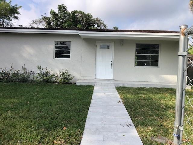 entrance to property with a lawn