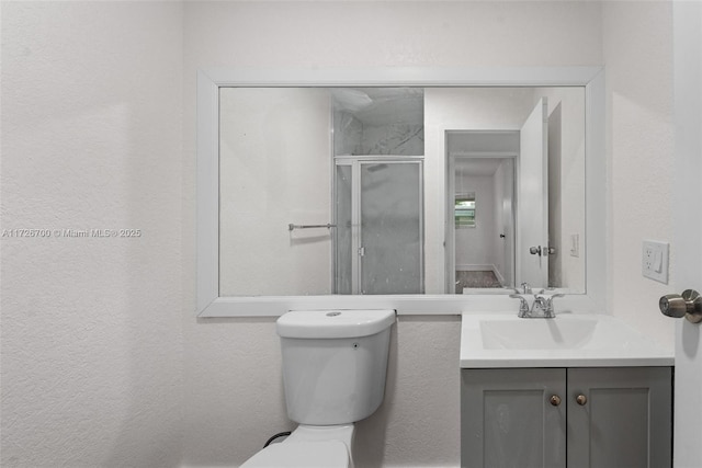 bathroom featuring an enclosed shower, vanity, and toilet