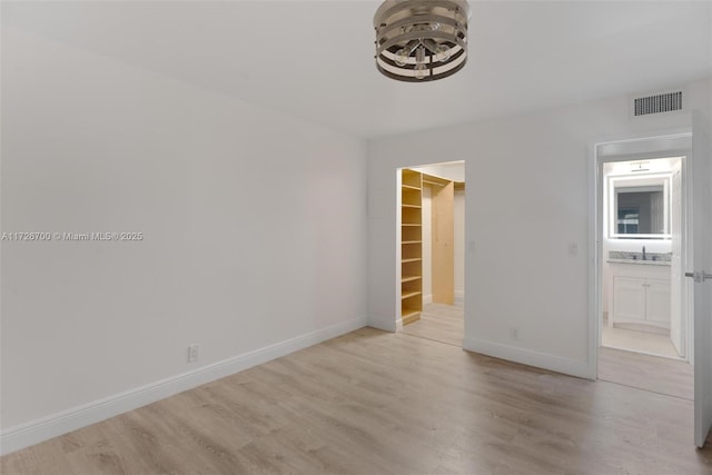 spare room with sink and light hardwood / wood-style flooring