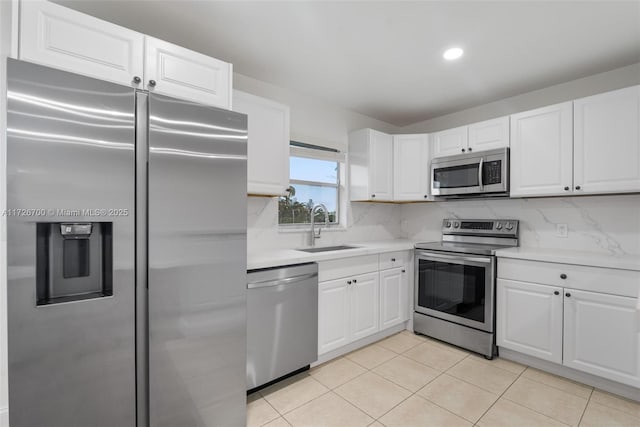 kitchen featuring sink, white cabinetry, backsplash, and stainless steel appliances