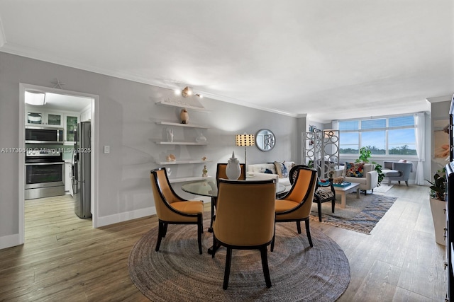 dining area featuring wood-type flooring and crown molding