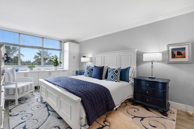 bedroom featuring ornamental molding and light hardwood / wood-style flooring