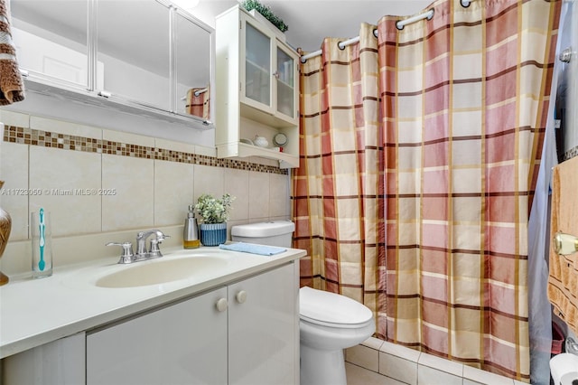 bathroom featuring tile walls, backsplash, toilet, walk in shower, and vanity