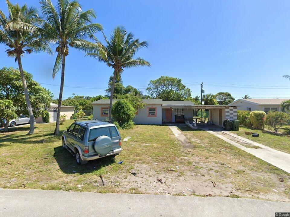 view of front of house featuring a front lawn and a carport