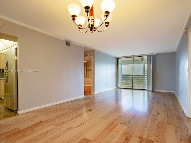 spare room with floor to ceiling windows, crown molding, a notable chandelier, and light wood-type flooring