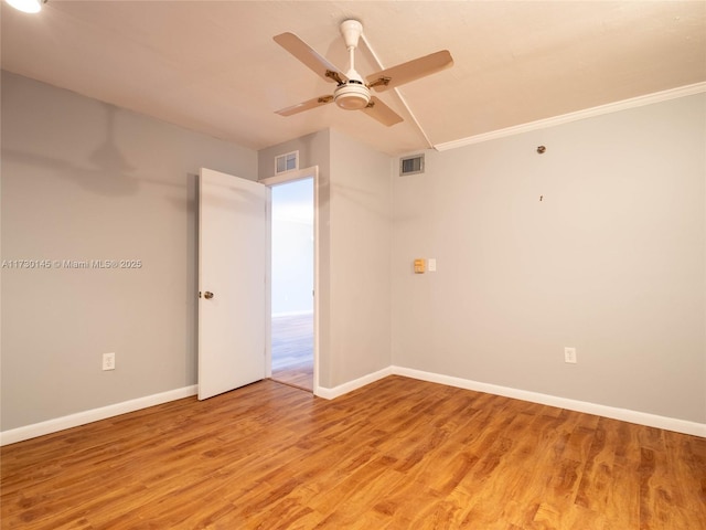 empty room featuring crown molding, hardwood / wood-style floors, and ceiling fan