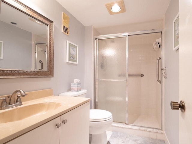 bathroom featuring toilet, a shower with shower door, tile patterned floors, and vanity