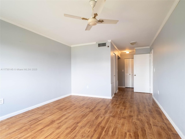 empty room featuring crown molding, hardwood / wood-style flooring, and ceiling fan