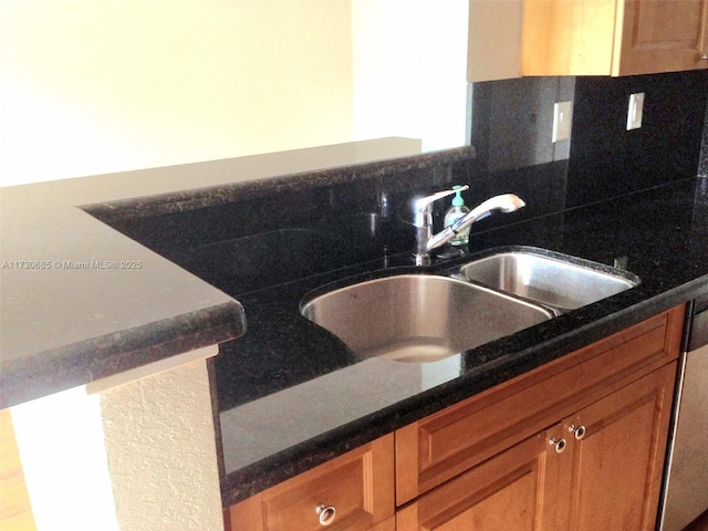 kitchen featuring tasteful backsplash, dishwasher, brown cabinetry, and a sink