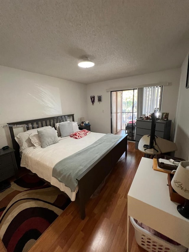 bedroom with dark wood-type flooring and a textured ceiling