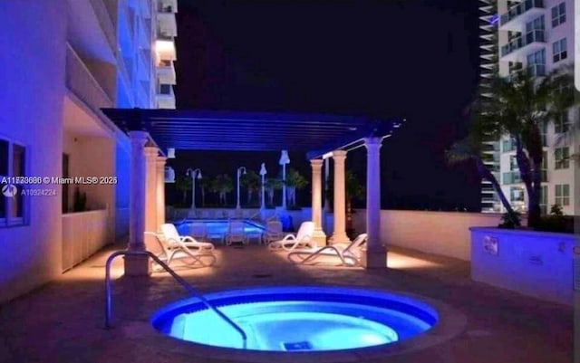 pool at twilight featuring fence, a patio, a hot tub, and a pergola