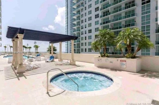 view of pool with a community hot tub, a patio, and a pergola