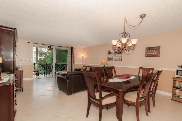 dining room with an inviting chandelier, a textured ceiling, and light tile patterned floors