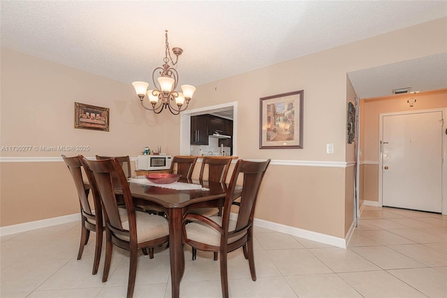 tiled dining area with a textured ceiling and a notable chandelier