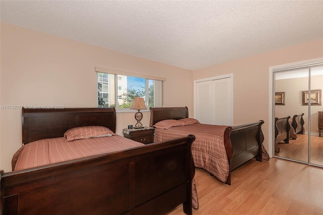 bedroom featuring a textured ceiling and light hardwood / wood-style flooring