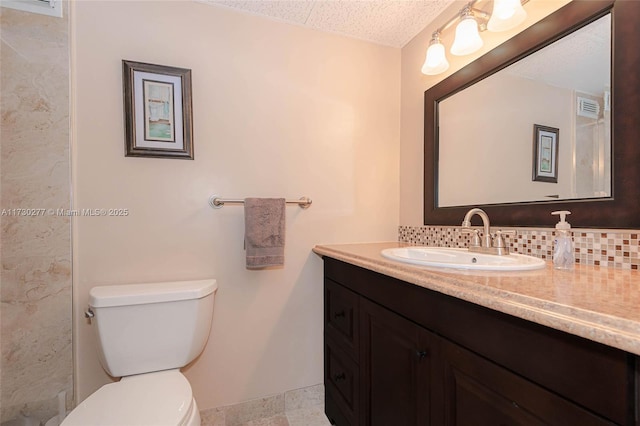 bathroom featuring vanity, backsplash, and toilet