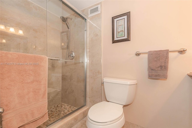 bathroom featuring toilet and an enclosed shower