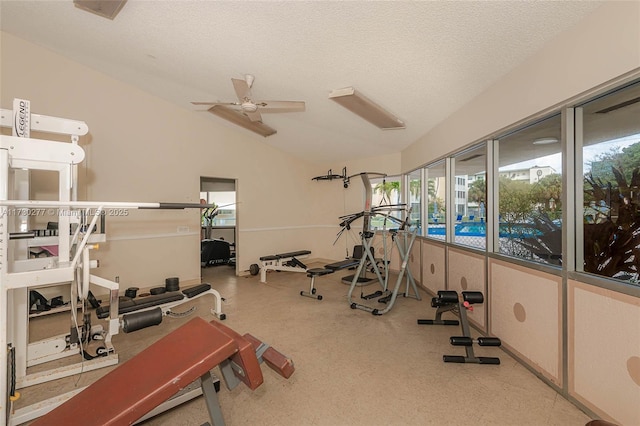 exercise room with ceiling fan, vaulted ceiling, a healthy amount of sunlight, and a textured ceiling