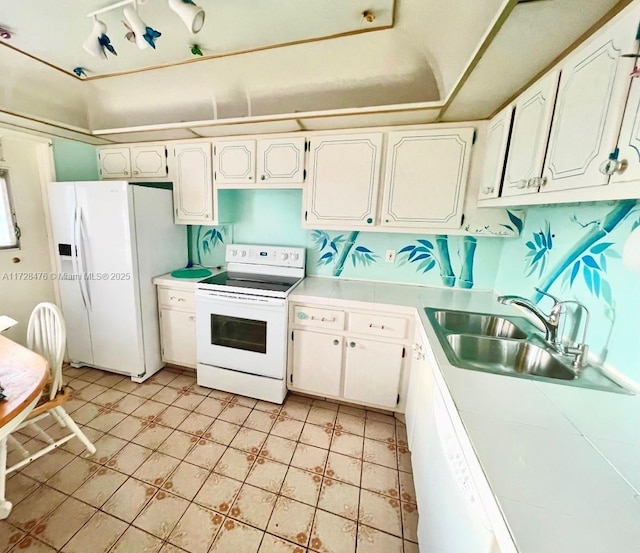 kitchen with tile countertops, white appliances, a sink, and white cabinets