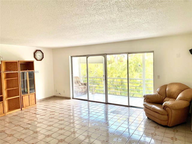 living room with a textured ceiling and baseboards