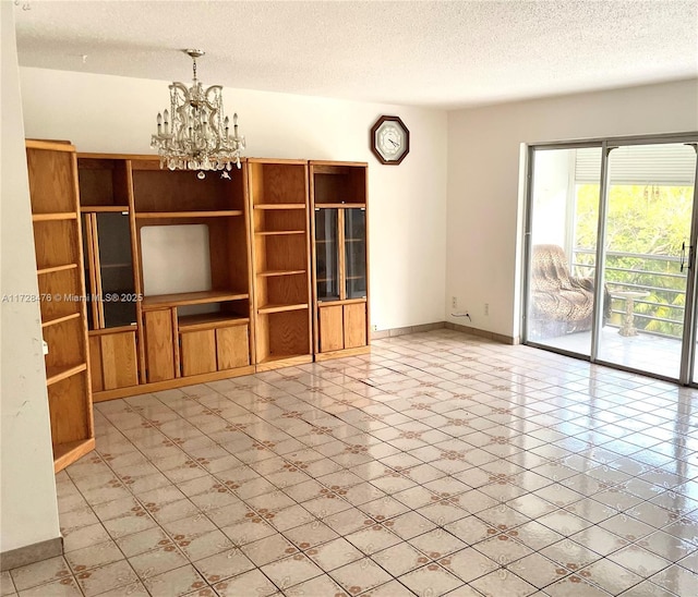 unfurnished living room featuring baseboards, a textured ceiling, and an inviting chandelier