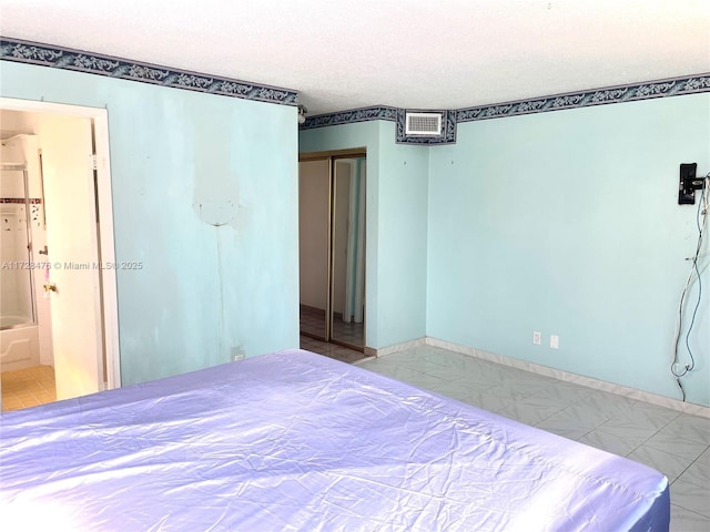 unfurnished bedroom featuring tile patterned flooring, a closet, and a textured ceiling