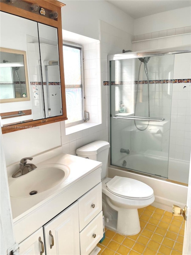 full bath with toilet, vanity, combined bath / shower with glass door, backsplash, and tile patterned floors