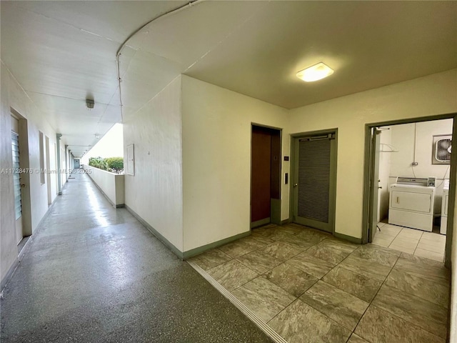 corridor with washing machine and dryer and baseboards