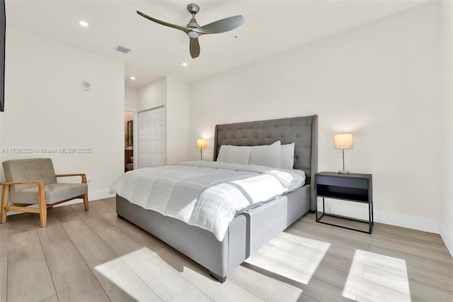 bedroom featuring light wood-type flooring, a closet, and ceiling fan