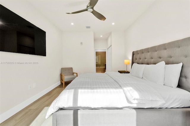 bedroom with light hardwood / wood-style floors, ensuite bath, and ceiling fan