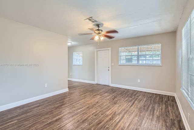 spare room with dark wood-type flooring and ceiling fan