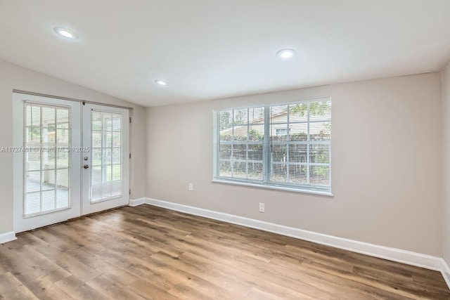 unfurnished room featuring french doors, vaulted ceiling, and hardwood / wood-style floors